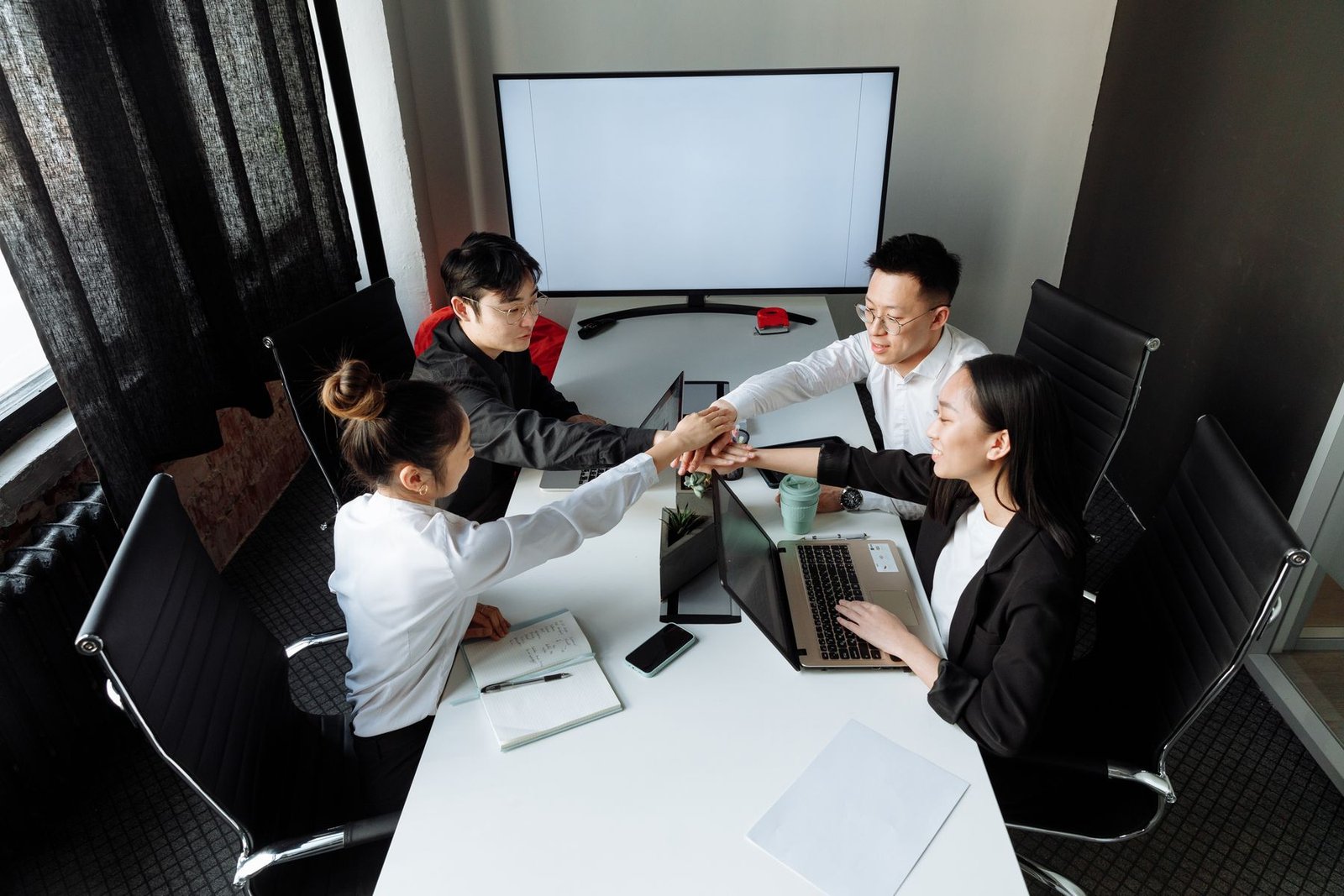 Team of Chinese logistics colleagues discussing a shipment plan together in the office